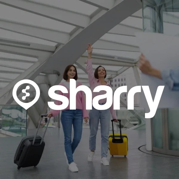 логотип і назва компанії Sharry на фоні дівчат, що йдуть по вокзалу з валізами